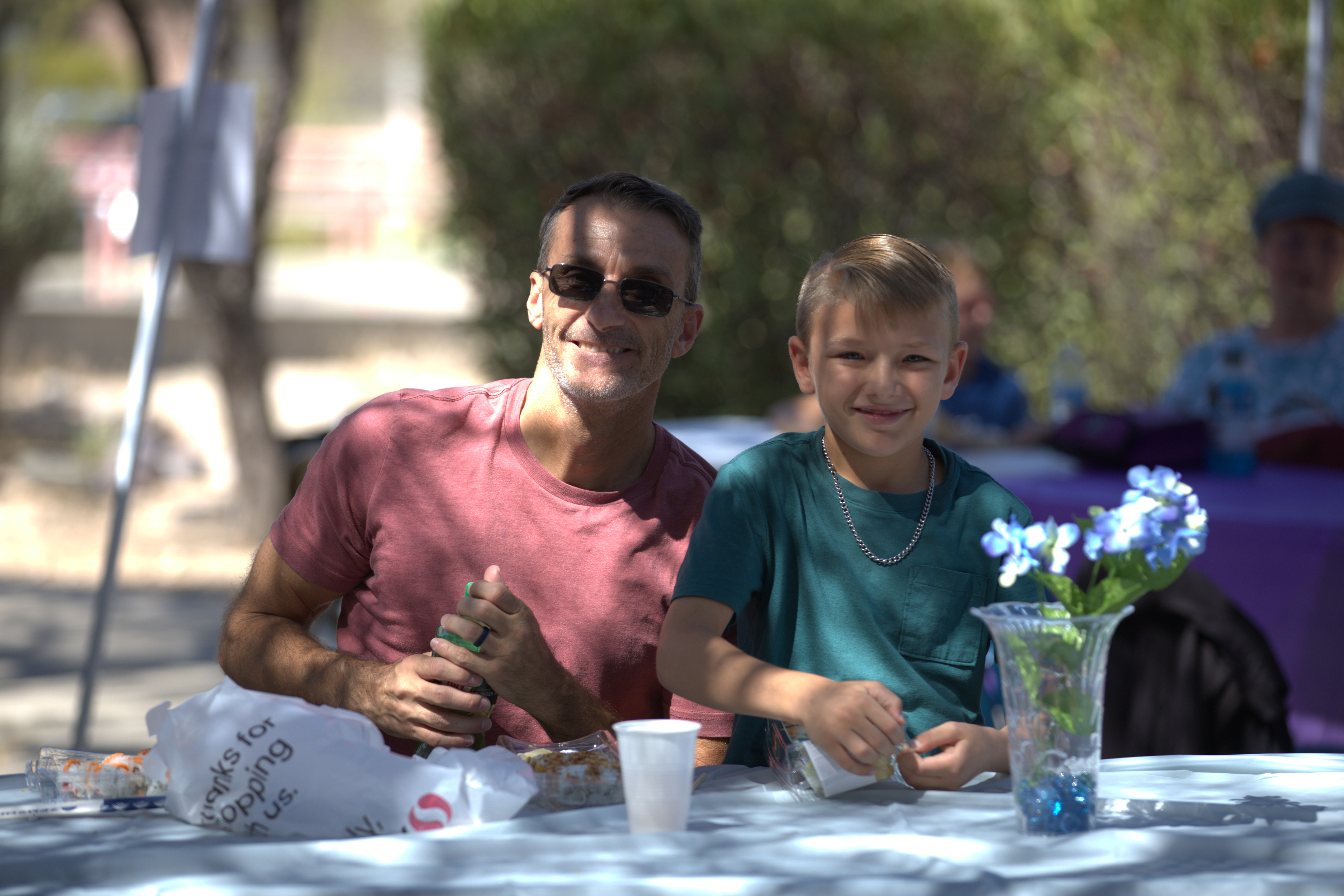 A grandpa in sunglasses smiles with his grandson