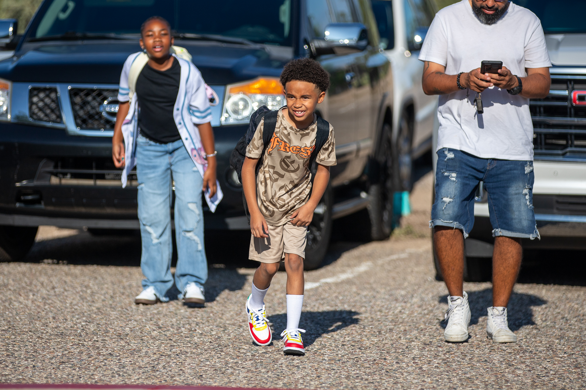 A boy is all smiles as he leaves the parking lot on the first day of school