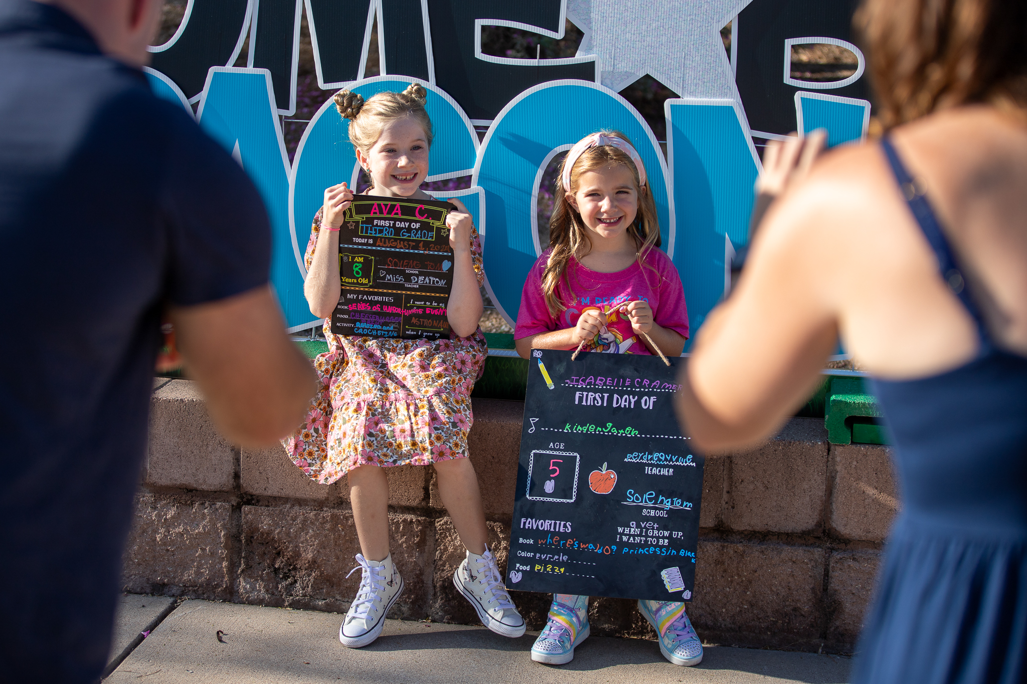 Two girls pose with their first day of school chalkboards