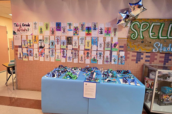 A wall and table displaying art projects