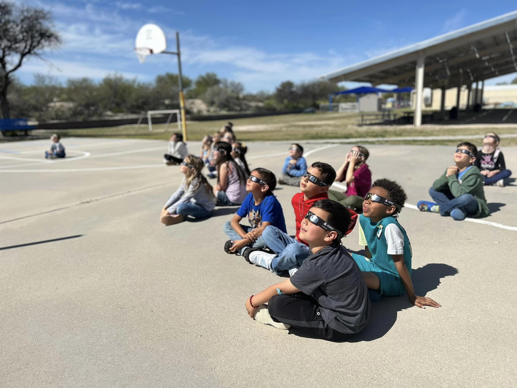 Students look up at the sky during the solar eclipse with their special glasses